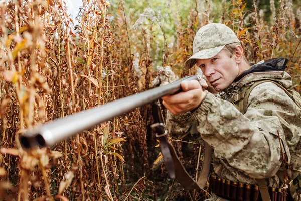 Man jägare med hagelgevär i skogen — Stockfoto