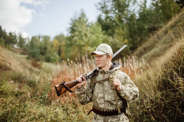 Man jägare med hagelgevär i skogen — Stockfoto