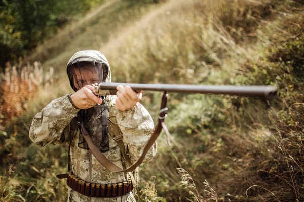 Мужчина с дробовиком в лесу — стоковое фото