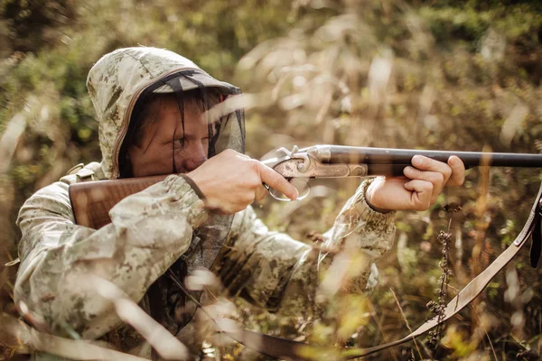 Cacciatore di uomini con fucile nella foresta — Foto Stock