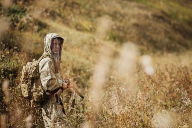 insan avcısı ormanda av tüfeğiyle