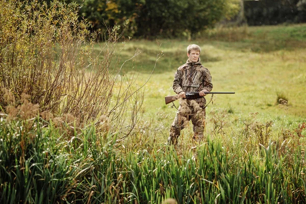 Lovec v maskovací oblečení připravené k lovu s lovecké pušky — Stock fotografie
