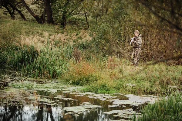 Охотник в камуфляжной одежде готов охотиться с охотничьей винтовкой — стоковое фото