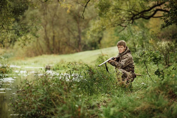 Chasseur en vêtements de camouflage prêt à chasser avec fusil de chasse — Photo