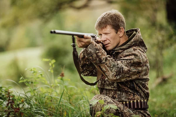 Hunter em roupas de camuflagem pronto para caçar com espingarda de caça — Fotografia de Stock