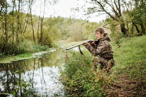 Hunter em roupas de camuflagem pronto para caçar com espingarda de caça — Fotografia de Stock