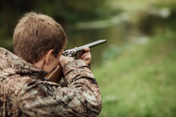 Hunter em roupas de camuflagem pronto para caçar com espingarda de caça — Fotografia de Stock