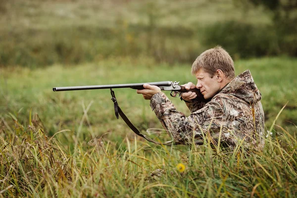 Hunter em roupas de camuflagem pronto para caçar com espingarda de caça — Fotografia de Stock