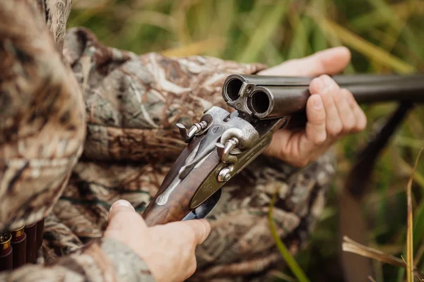 Hunter em roupas de camuflagem pronto para caçar com espingarda de caça — Fotografia de Stock