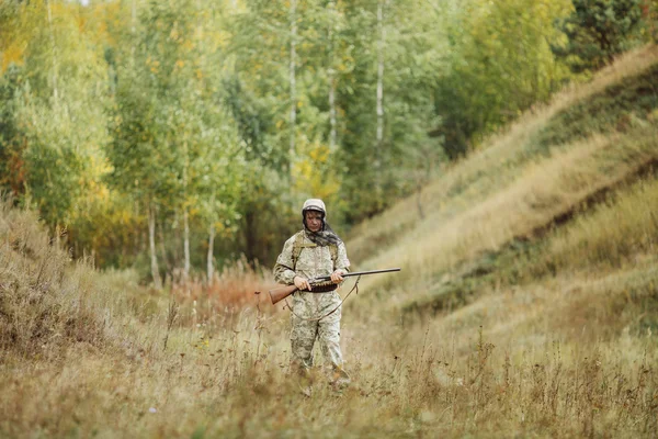 Hunter en ropa de camuflaje listo para cazar con rifle de caza — Foto de Stock