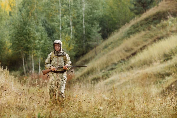 Avcı av tüfeği ile avlamak hazır kamuflaj giysili — Stok fotoğraf