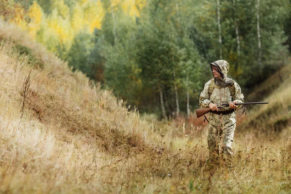 Hunter en ropa de camuflaje listo para cazar con rifle de caza — Foto de Stock