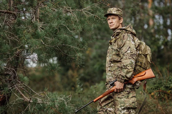 Hunter em roupas de camuflagem pronto para caçar com espingarda de caça — Fotografia de Stock