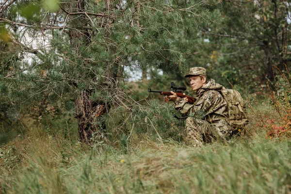 Hunter em roupas de camuflagem pronto para caçar com espingarda de caça — Fotografia de Stock