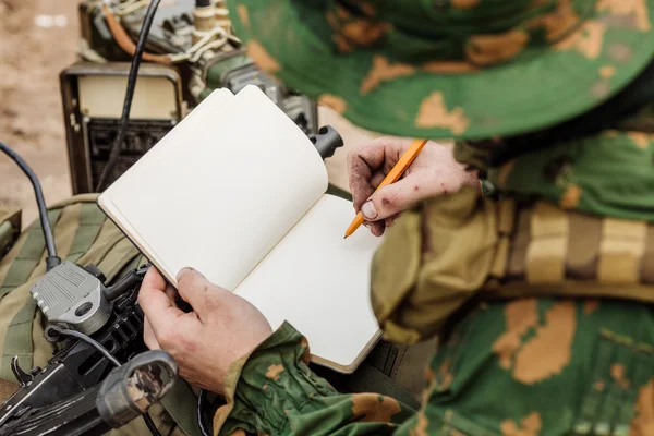 Radio operator taking notes and radio — Stock Photo, Image