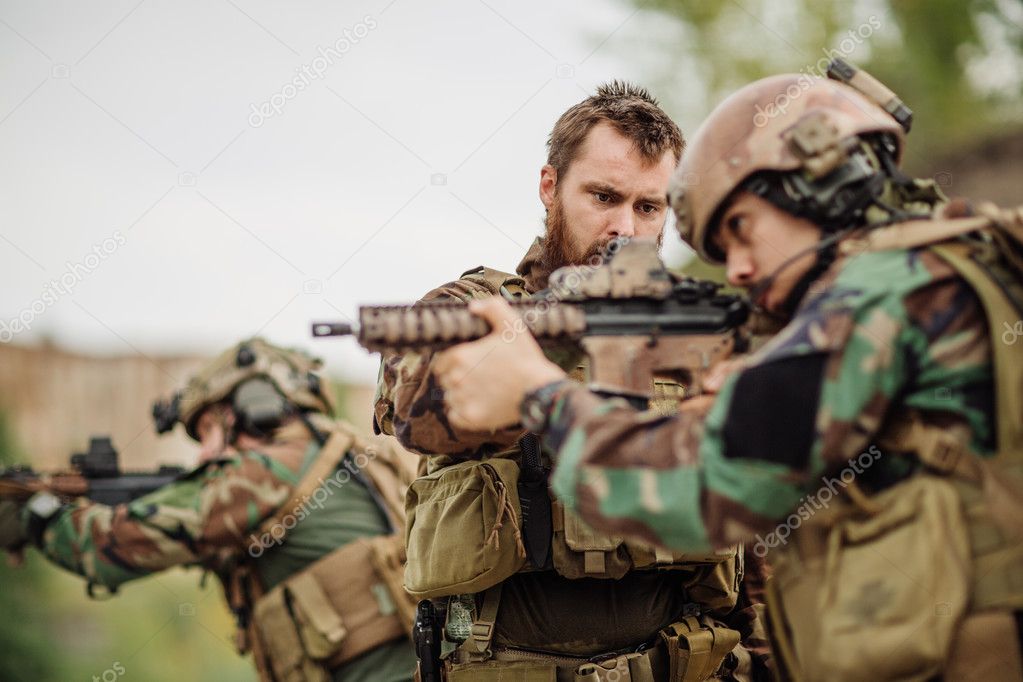 us Instructor with soldier aiming rifle at firing range