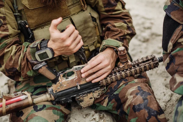 Ремонт солдата закріпити гвинтівку за допомогою інструменту на полі бою — стокове фото