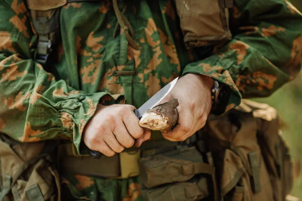 Солдат с ножом порезал деревянную палку — стоковое фото