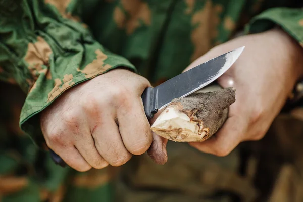 Soldado com uma faca cortar uma vara de madeira — Fotografia de Stock