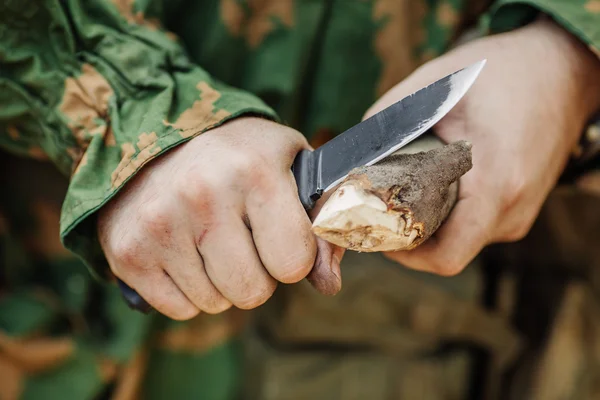Soldat zerschnitt mit Messer einen Holzstock — Stockfoto