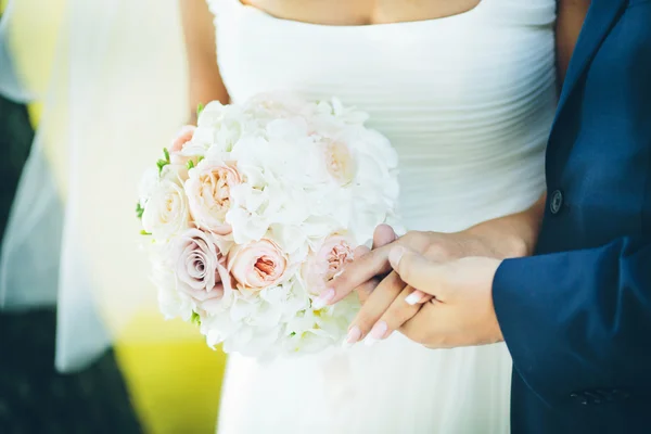 Buquê com flores rosa nas mãos do noivo e noiva — Fotografia de Stock