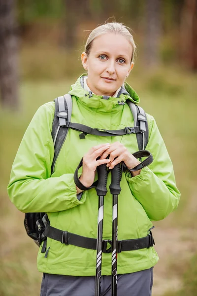 Mujer con equipo de senderismo caminando en el bosque — Foto de Stock