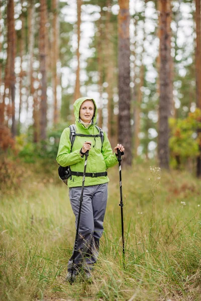Donna con attrezzatura per escursioni a piedi nella foresta — Foto Stock