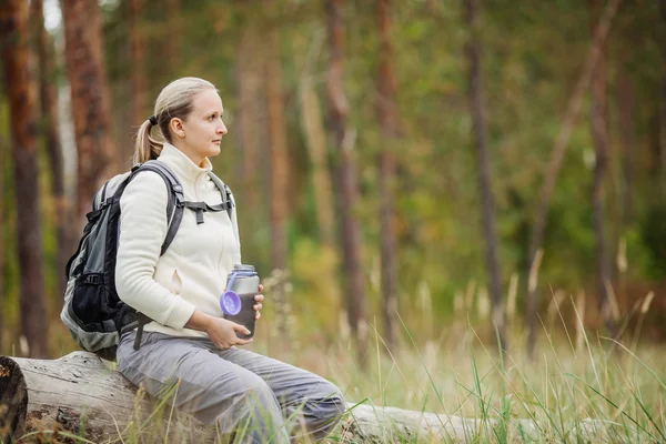 Mujer joven bebiendo agua con mochila en el valle del bosque — Foto de Stock