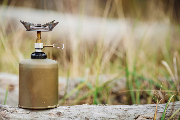 gas stove on wood on forest background. Lunch during the journey