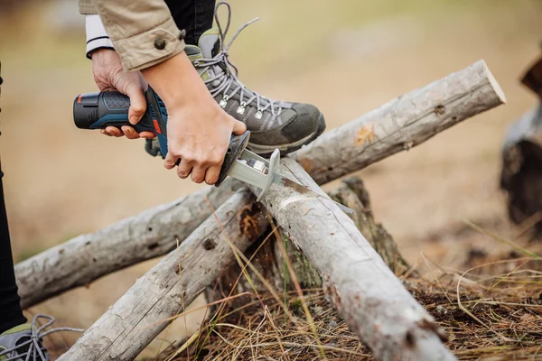 Женщина режет дерево ручной электропилой — стоковое фото