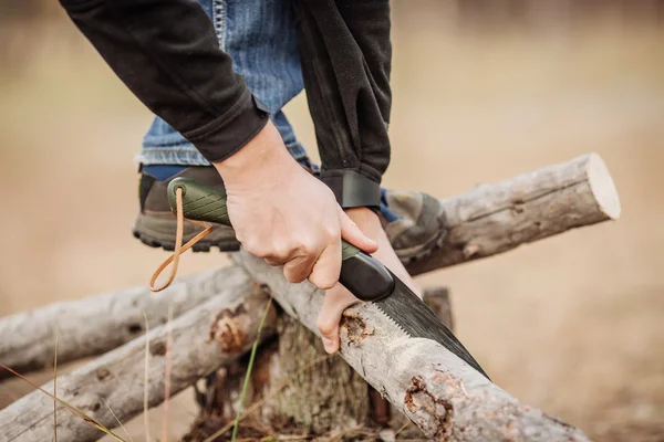 Yang homme couper un bois avec une scie à main — Photo