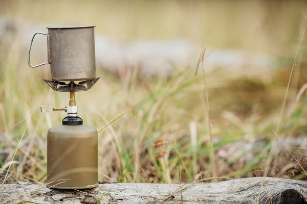 Estufa de gas con taza de titanio en el fondo del bosque —  Fotos de Stock