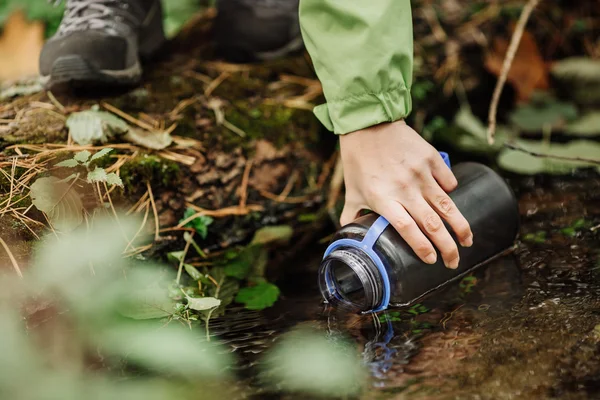 Orman bahar gezisi hiking üzerinde su alarak kadın