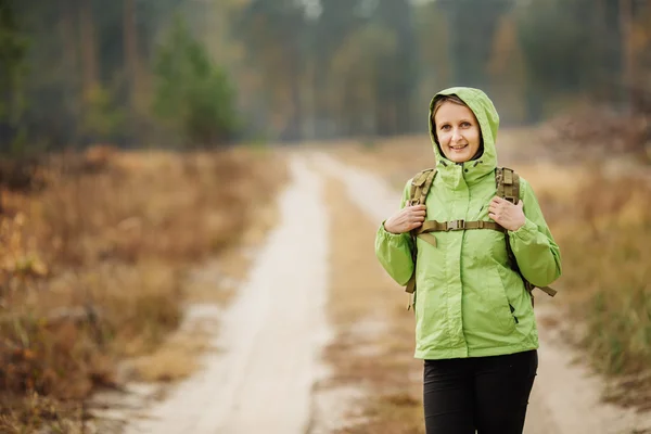 Donna con attrezzatura per escursioni a piedi nella foresta — Foto Stock