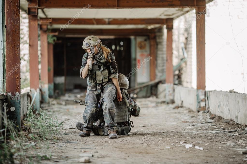 woman medic soldiers evacuate the injured fellow in arms in the