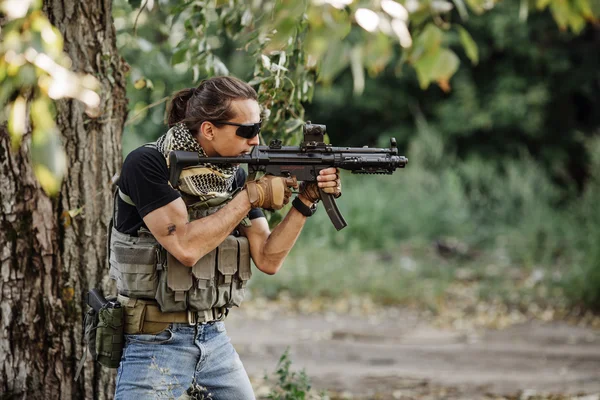 Terrorist aiming his rifle on battlefield background — Stock Photo, Image