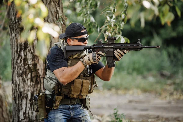 Terrorista apontando sua espingarda no fundo do campo de batalha — Fotografia de Stock