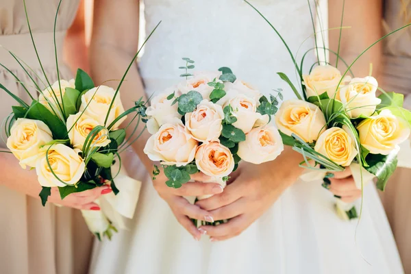 Bruidsmeisje jurken houden boeketten in een rustieke stijl — Stockfoto