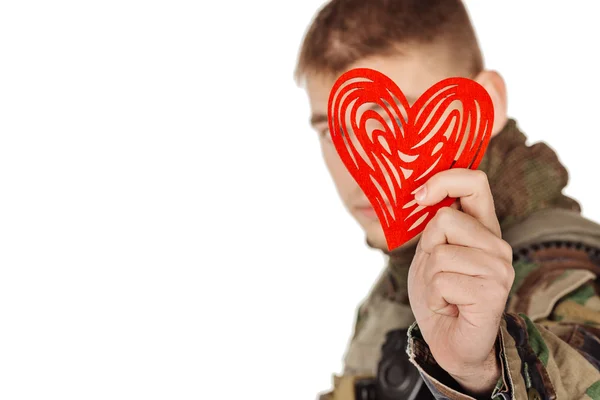 Soldier holding heart shaped valentine card and smiling while st — Stock Photo, Image