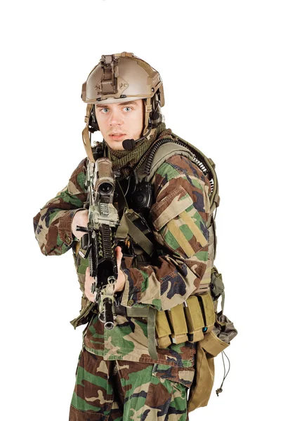 Young ranger standing with a machine gun at white background — Stock fotografie