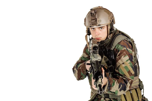 Young ranger standing with a machine gun at white background — Stockfoto