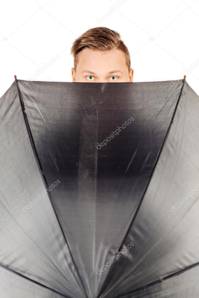 young man hidden in umbrella against white background