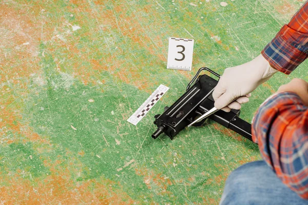Criminalist preventing gun at the murder scene — Stock Photo, Image