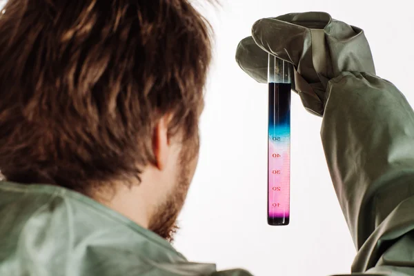 Man with protective mask and protective clothes examines a water sample — Stock Photo, Image