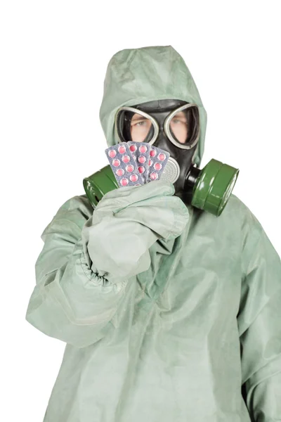 Homem com máscara protetora e roupas protetoras segurando pílulas — Fotografia de Stock