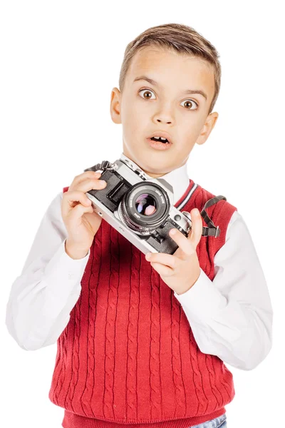 Feliz niño fotógrafo sosteniendo una cámara de cine aislado en blanco — Foto de Stock