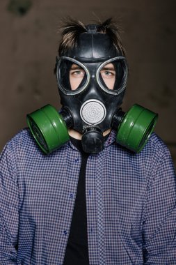 Adam kameraya bakarak koruyucu gaz maskesi