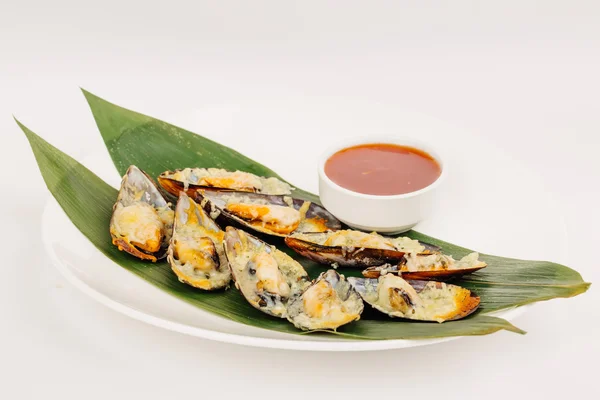 Mussels baked with sauce on a tropical leaves for restaurant menu cafe — Stock Photo, Image