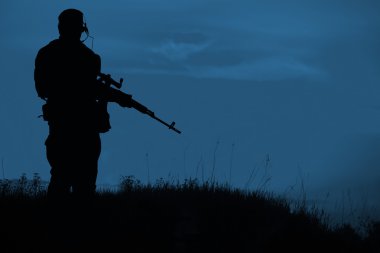 Geceleri keskin nişancı tüfeği ile askeri keskin nişancı silueti. Atış, 