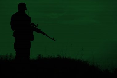 Geceleri keskin nişancı tüfeği ile askeri keskin nişancı silueti. Atış, 